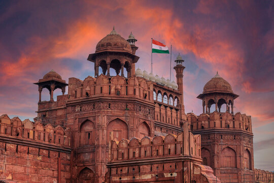 Red Fort or Lal Qila in Delhi with indian flag on foreground with moody sk.UNESCO World heritage site. Discover the India. Open world after covid-19 - Powered by Adobe