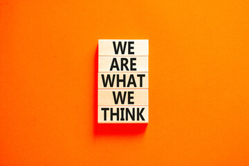 We are what we think symbol. Concept word We are what we think on wooden block. Beautiful orange table orange background. Business We are what we think concept. Copy space.