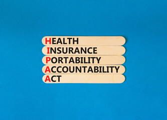 HIPAA symbol. Concept words HIPAA health insurance portability accountability act on wooden stick. Beautiful blue background. Business HIPAA health insurance portability accountability act concept.