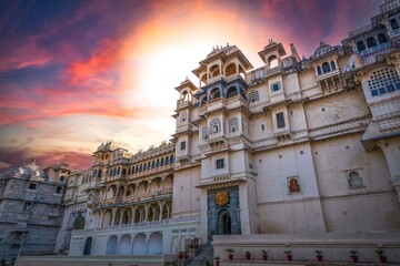 Naklejka na ściany i meble Romantic and luxury City Palace of Maharajah in Udaipur on Lake Pichola at sunset. Rajasthan, Discover the beauty of India. Open world after covid-19