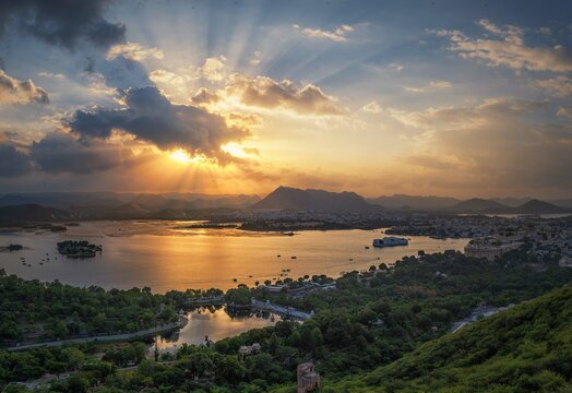 Aerial panoramic view of Udaipur, Lake palace, Lake Pichola at beautiful sunset and moody sky. Rajasthan, Discover the beauty of India. Open world after covid-19