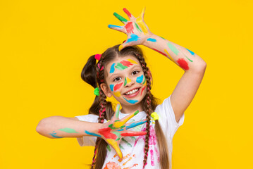 Childish pranks. A charming child with painted palms with multicolored paints. A little girl...