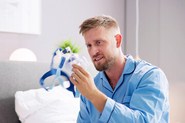 Shocked Young Man Holding CPAP Machine