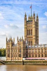 View across Thames river to Victoria tower at Westminster palace in London. Copy space in sky. - 614234294
