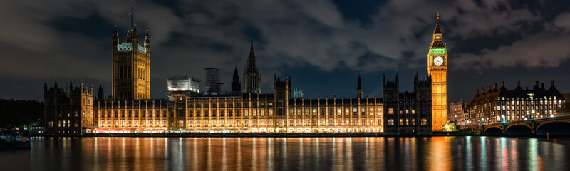 Night panoramic view across river Thames to Palace of Westminster in London.