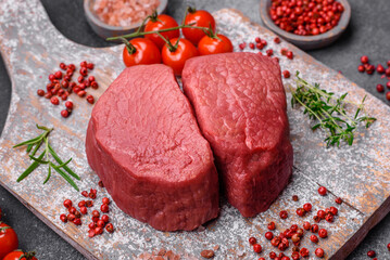 Raw beef eye steak round with salt, spices and herbs