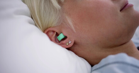 Woman Sleeping With Earplugs In Her Ears