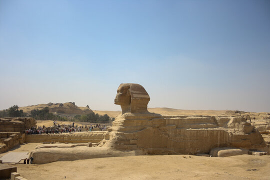 vista lateral de la esfinge de Gizeh en un d&iacute;a soleado y caluroso con turistas visitando 