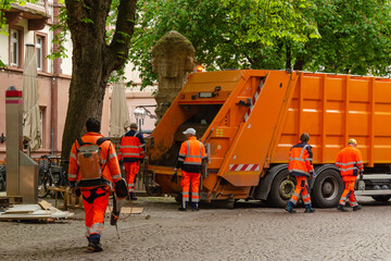 Rubbish collection in the city by street cleaners with a rubbish truck.