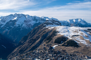 Fototapeta na wymiar Ski resort on snow covered mountains, bare mountains due to heavy melting, Les Deux Alpes, Isère, Auvergne-Rhône-Alpes, France, January 2023 (1/3)