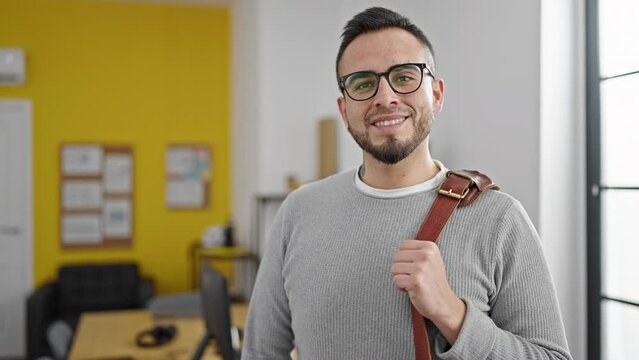 Hispanic man business worker smiling confident holding briefcase at office