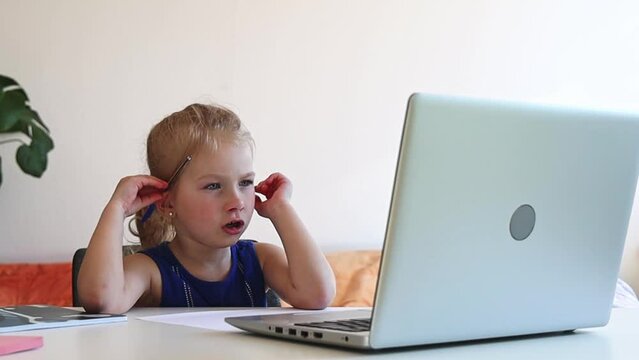 Girl watching educational video on laptop.