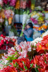 Puesto donde se venden de flores en el mercado de San Pedro, en Cusco, Peru. Flores coloridas, blancas, rojas, naranjas. 