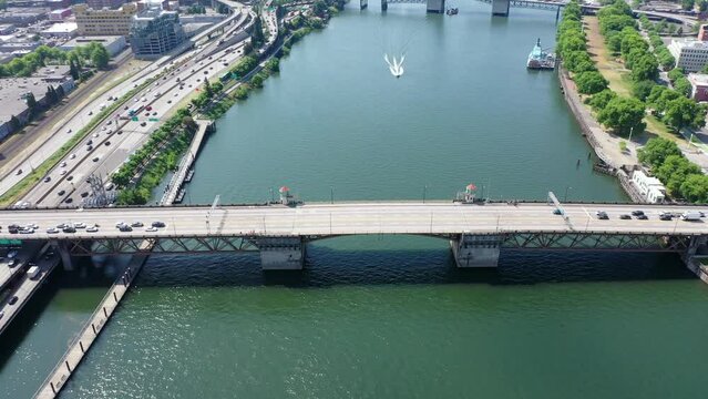 Portland Oregon, USA - June 28 23, steady flight above Willamette River with closed double-leafs bascule Burnside Bridge  - traffic is waiting before the start crossing the bridge, aerial footage