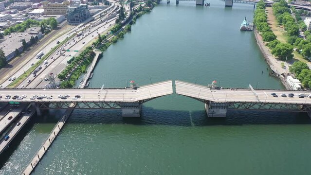 Portland Oregon, USA - steady flight above river Willamette with Burnside Bridge just closing the double-leafs bascule - traffic is still waiting - aerial cityscape, aerial video footage
