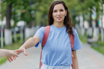 young girl extends her hand to a meeting, and offers friendship