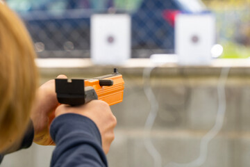 Hand-held orange laser sports pistol while aiming
