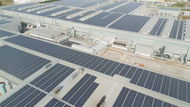 Aerial view of solar panels or solar cells on the roof of factory building rooftop. Power plant, renewable clean energy source. Eco technology for electric power in industry.