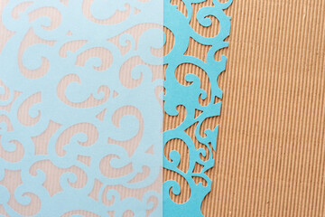 card stock paper background with blue die-cut sheet with fancy shapes and brown corrugated paper