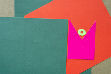 mostly green, orange, and pink shape background with distinctive green paper ring