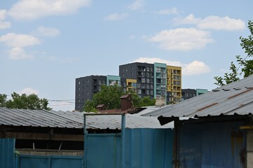 Fototapeta premium Almaty urban landscape with old house roofs and new buildings beside