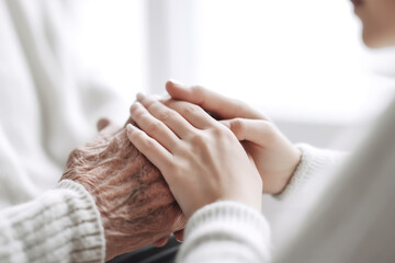 Young woman holding senior man hands, close up. Care and support concept 