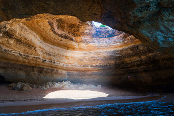Benagil cave,with a small beach and a hole in its upper part,in the cliffs of the Algarve,Portugal.