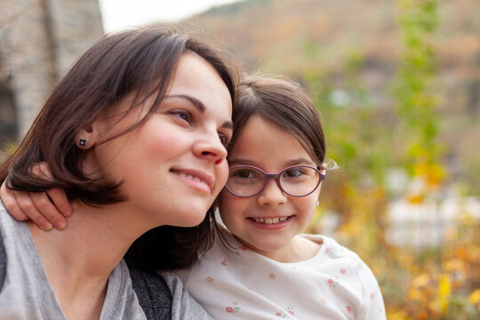 Portrait of a mother and her daughter on the nature in autumn