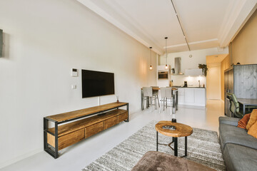 a living room with couches and a flat screen tv mounted on the wall in the room is very clean