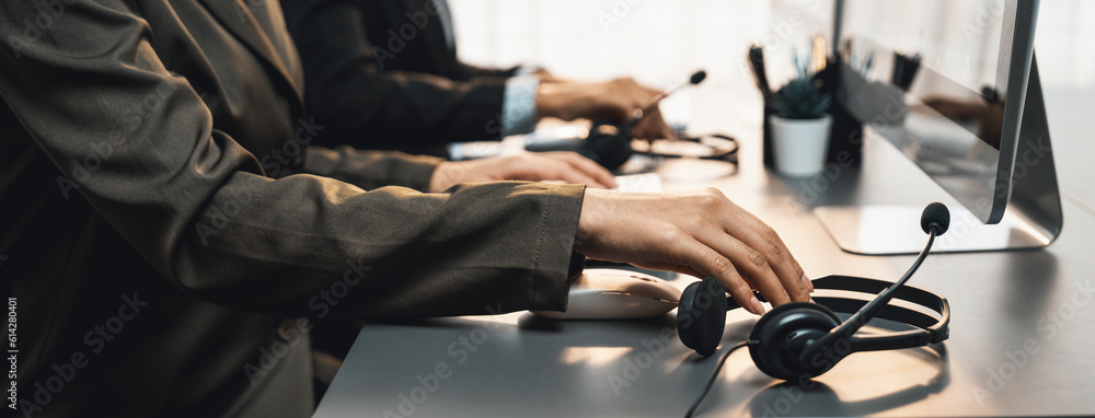 Aufkleber panorama focus hand holding headset on call center workspace desk with blur background of operator t