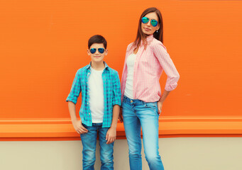 Stylish happy smiling mother with son teenager posing together in sunglasses, checkered shirts,...