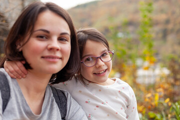 Fototapeta premium Portrait of a happy mother and her daughter in the autumn park