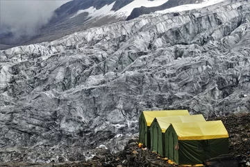 Crédence de cuisine en verre imprimé Manaslu Vibrant green and yellow expedition tents stand against the stunning Manaslu Glaciers at the renowned Manaslu Base Camp in the Nepalese Himalayas.