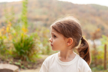 Portrait of a cute little girl with ponytail in the countryside