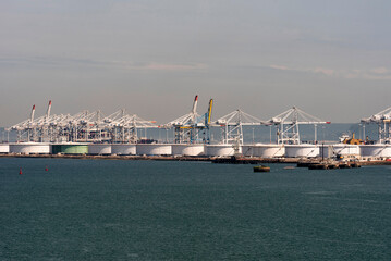 Le Havre, northern France, Europe. 2023. Cranes in the container port and storage  tanks alongside...