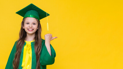 A child in a graduate hat points to your advertisement and ad. A little schoolgirl in a master's...