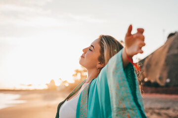 Portrait of one young woman at the beach with openened arms enjoying free time and freedom outdoors. Having fun relaxing and living happy moments.. © Daniel