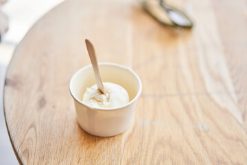 Vanilla ice-cream in disposable cups on the table. Italian gelateria. Natural fresh gelato. 