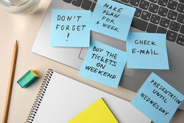 Different reminder notes and laptop on white table, flat lay