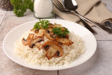 Delicious rice with parsley and mushrooms on tiled table