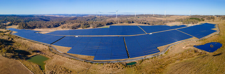 Panoramic low aerial view of the hybrid Gullen Solar Farm and Gullen Range Wind Farm for renewable clean energy supply located at Bannister in the Upper Lachlan Shire, NSW, Australia