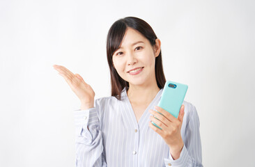 スマートフォンを持って左側を案内するミドルエイジ女性　白背景