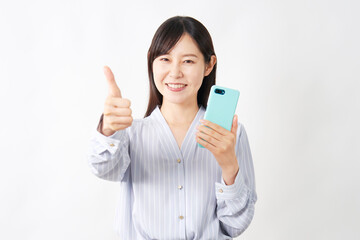 Fototapeta premium スマートフォンを持ってグッドポーズするミドルエイジ女性 白背景