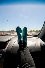 Feet on the dashboard of the car while traveling on route.