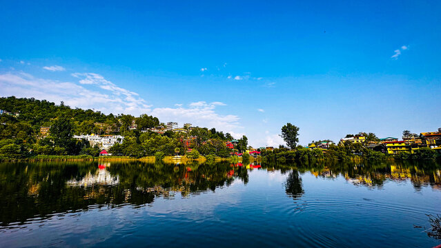 A beautiful landscape view of rewalsar lake with reflection of mountains.