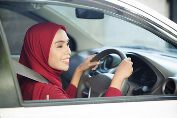 Beautiful businesswoman with hijab is smiling in her car