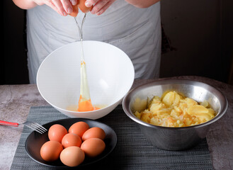woman pouring an egg into a splash bowl with a plate with eggs and a bowl of potatoes - Powered by Adobe