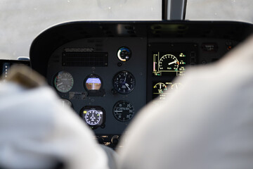 Helicopter pilot at controls with instrument panel showing airspeed and altimeter, among with other...