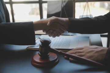 Justice and law concept.Male judge in a courtroom with the gavel, working with, computer and docking keyboard, eyeglasses, on table in morning light