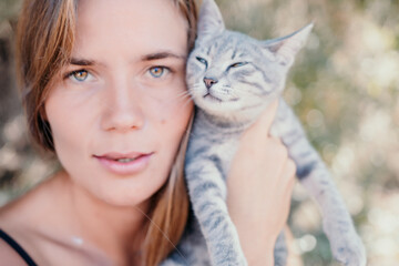 Woman summer travel cat. A woman on vacation with her pet cat enjoying a photo session on the beach. Travel and holiday concept.